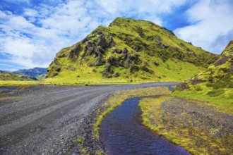 Picturesque basalt hills covered with green grass and moss-polar. At the bottom of the canyon