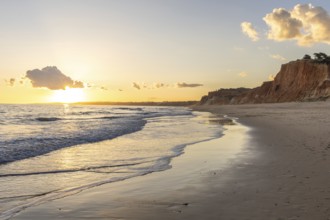 The golden sandy beach of Praia da Falésia, crystal clear sea water at low tide with the reflection