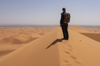 Hiking up the Great Dune of Merzouga in the Erg Chebbi desert, Moroccan Sahara desert