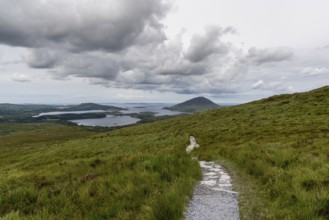 The hiking trail descending from Diamond Hill mountain peak in Connemara National Park with a view
