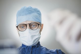 Medical professional in surgical attire concentrating in a hospital setting