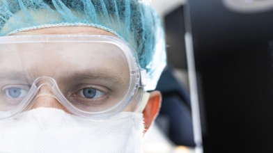Close-up of a doctor wearing transparent goggles and a face mask