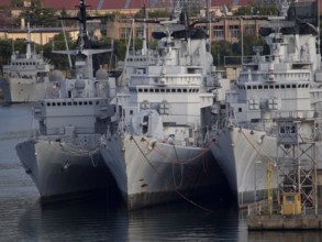 Three large military ships side by side in an industrial harbour area, la specia, Italy, Europe