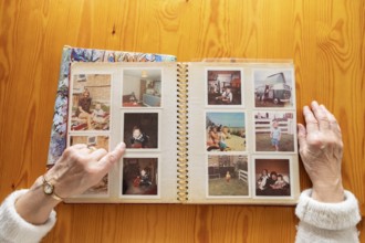Top view of a senior caucasian woman looking at an old photo album themes of memories nostalgia