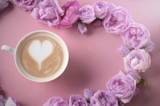 Cup of coffee around may roses against pink background. romantic and beauty concept