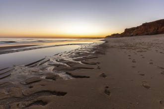 What a sandy beach on the Atlantic. Landscape shot at sunset on a coast with sandstone cliffs. Low