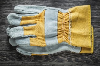 Protective gloves on wooden board top view