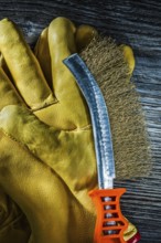 Scratch wire brush leather safety gloves on vintage wooden board