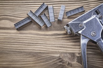 Construction stapler staples on wooden board top view