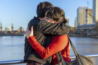 LGBT couple of women embracing each other on a bridge, enjoying a moment of connection