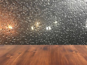 Old brown oak wood table on the blurry drop on window background, wooden table