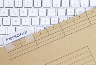 The photo shows a white keyboard with a personnel file