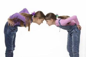 Quarrel two girls standing leaning their foreheads against to each other