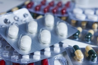 Close-up view of mixed blister packs containing white and colored capsules