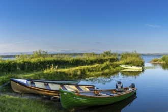 Buckode, Ireland, 15 July, 2022: warm evening light at Lough Melvin light with colorful wooden