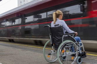 A young woman sits in a wheelchair at a railway station in Austria