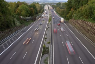 Night lights from car headlights on roundabout in night city. Traces of headlights on the road at
