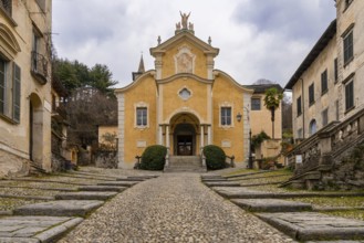 Orta San Giulio, Italy, 13 March, 2023: steep cobblestone street leading to the historic Penotti