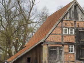 Half-timbered house with striking gable and red roof tiles. Rustic and old-fashioned building with