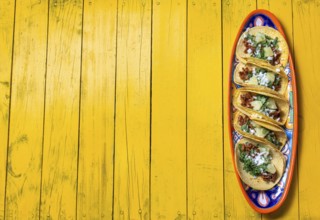 Food, Food, Mexican background with tacos al pastor and mexican sauces. Yellow wooden background,