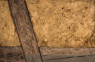Clay house wall, with details on the wooden beams and the mixture of mud and straw, perfect as