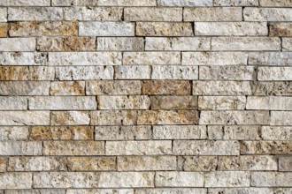 Background consisting of a wall of beige and brown clinker bricks