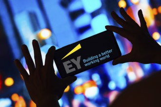 In this photo illustration, the Ernst and Young Global Limited (EY) logo is displayed on a