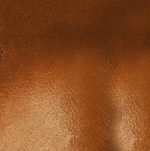 Metallic textured background in shades of orange reflecting light and creating a gradient effect