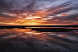 Majestic sunset with clouds in moviment reflected in the water