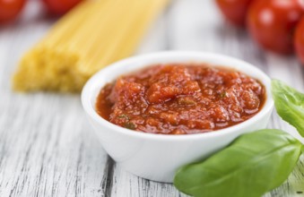 Tomato Sauce on rustic wooden background (close-up shot)