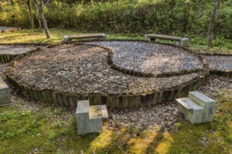 Yin yang symbol made of wooden posts and cemented rocks in wilderness park, Gongju, South Korea,