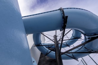 An exciting and vibrant blue water slide elegantly twisting through the bright sky at a popular