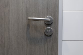 A stylish door handle rests on a beautiful wooden surface, perfectly showcasing modern design and