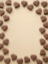 Frame of romantic chocolate confections in heart shapes on pastel yellow background. Canvas with