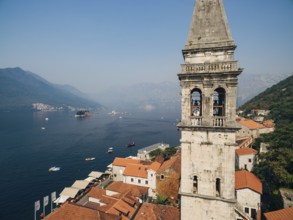The bride and groom hug in the window of the ancient tower in the old town of Perast .