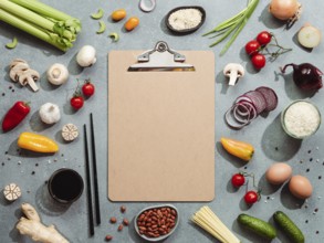 Asian ingredients and empty clipboard. Various of Chinese cooking ingredients and chopsticks on
