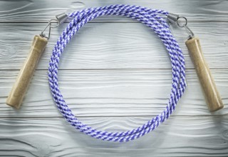 Jumping rope with wooden handles on wood board sports training concept