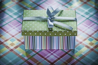 Present in cardboard box on checked fabric holidays concept