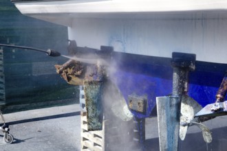 Pressure washer cleaning boat hull barnacles antifouling and seaweed