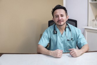 Portrait of a Latino doctor sitting at his desk