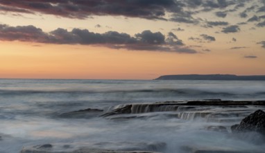 Dramatic beautiful sunset on a rocky coast at Akrotiri area in Limassol, Cyprus. Long exposure