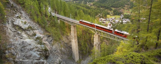 Zermatt, Switzerland. Gornergrat red tourist train on the bridge in Swiss Alps banner panorama