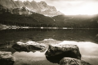 Dreamy monochrome landscape with the clear water of the Eibsee lake and the German Alps mountains