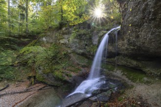 A waterfall in the forest with sunbeams through the trees, peaceful and natural, Hasenreuter