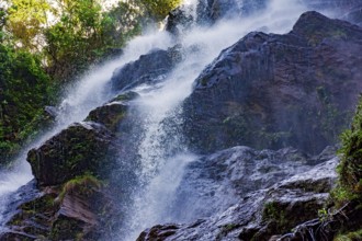 Water running through the rocks and forest forming a beautiful waterfall in Minas Gerais, Brazil,