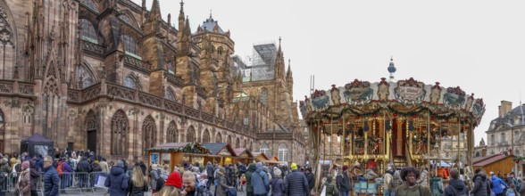 Panoramic photo of the carousel at the Christmas market at the High Gothic Strasbourg Cathedral,