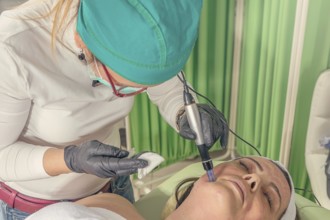 Beautician performs a needle mesotherapy treatment on a woman face