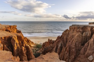 View from one, eroded cliffs of red sand and pebbles with stunning formations illuminated by a warm