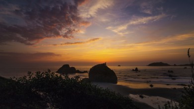 This is a color landscape photo of a vivid sunset over the Pacific Ocean
