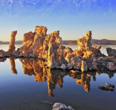 Orange sunset. The magic of Mono Lake. Outliers - calcareous tufa formation on the smooth water of